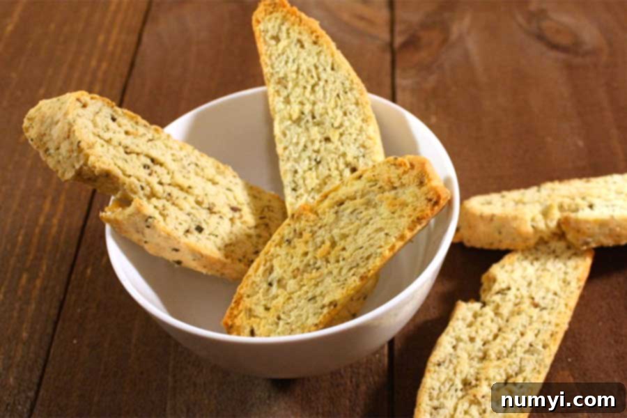 Finished savory herb and cheese biscotti elegantly presented in a rustic white bowl, ready for serving.