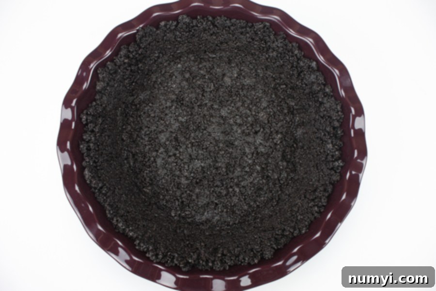 Butterfinger Dream Pie 4 Crushed Oreo cookies pressed into a vibrant purple pie plate, forming the crust.