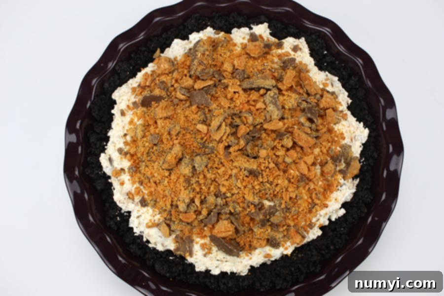 Butterfinger Dream Pie 7 A completed Butterfinger pie, assembled and ready for chilling in a purple pie plate.