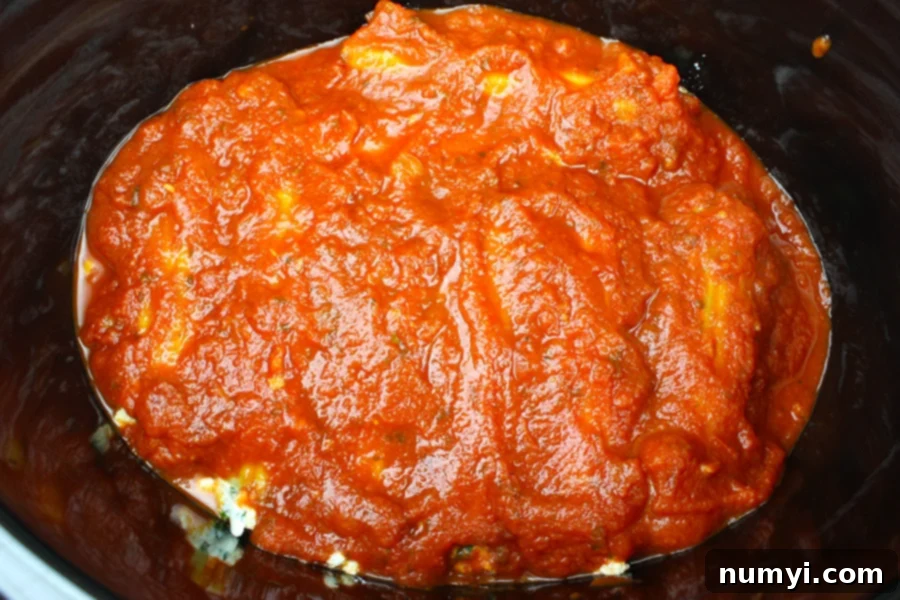 Slow Cooker Manicotti covered with marinara sauce in the crockpot.