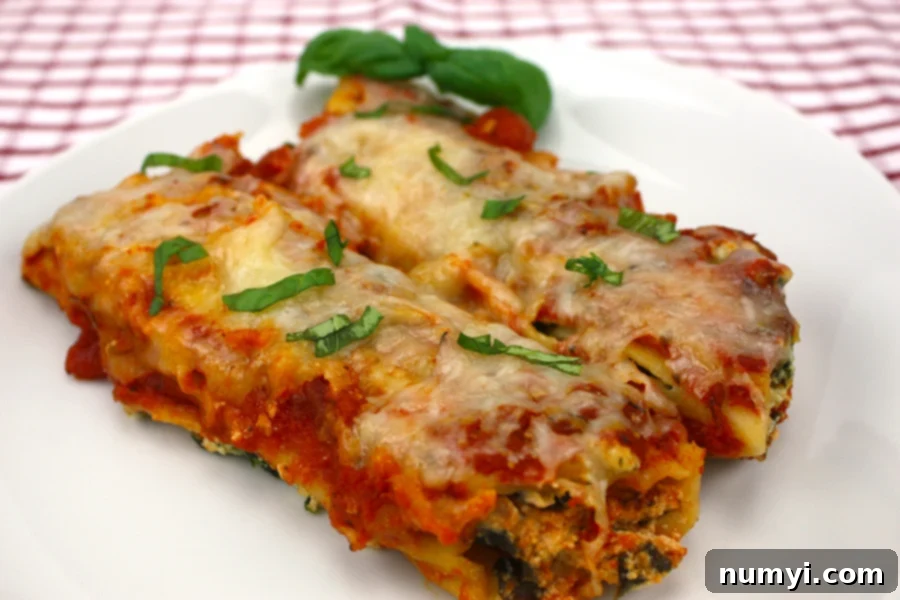 Slow Cooker Manicotti served on a white plate, garnished with fresh basil.