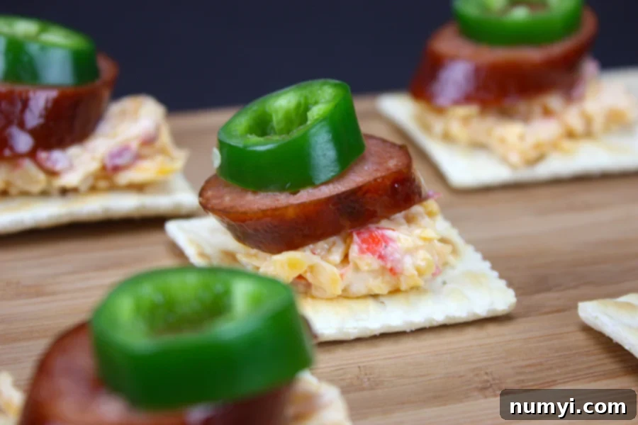 Homemade pimento cheese generously spread on crackers, crowned with slices of warm smoked sausage and zesty jalapeños.