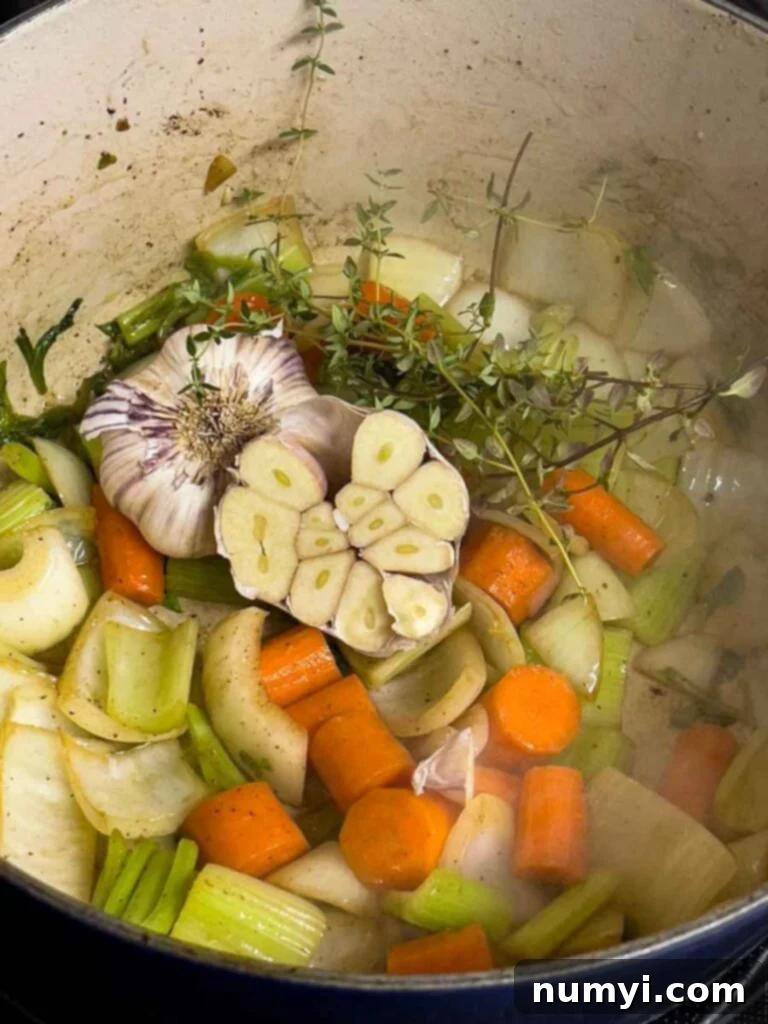 Roughly chopped carrots, celery, and onion cooking in a Dutch oven, softening and releasing their aromas.