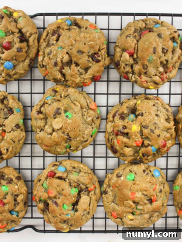Freshly baked Monster cookies cooling on a wire rack, showing their thick and chewy texture.