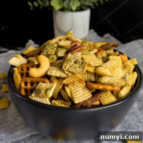 Tangy Dill Chex Crunch 9 Dill Pickle Chex Mix in a small dark bowl on a light linen napkin.