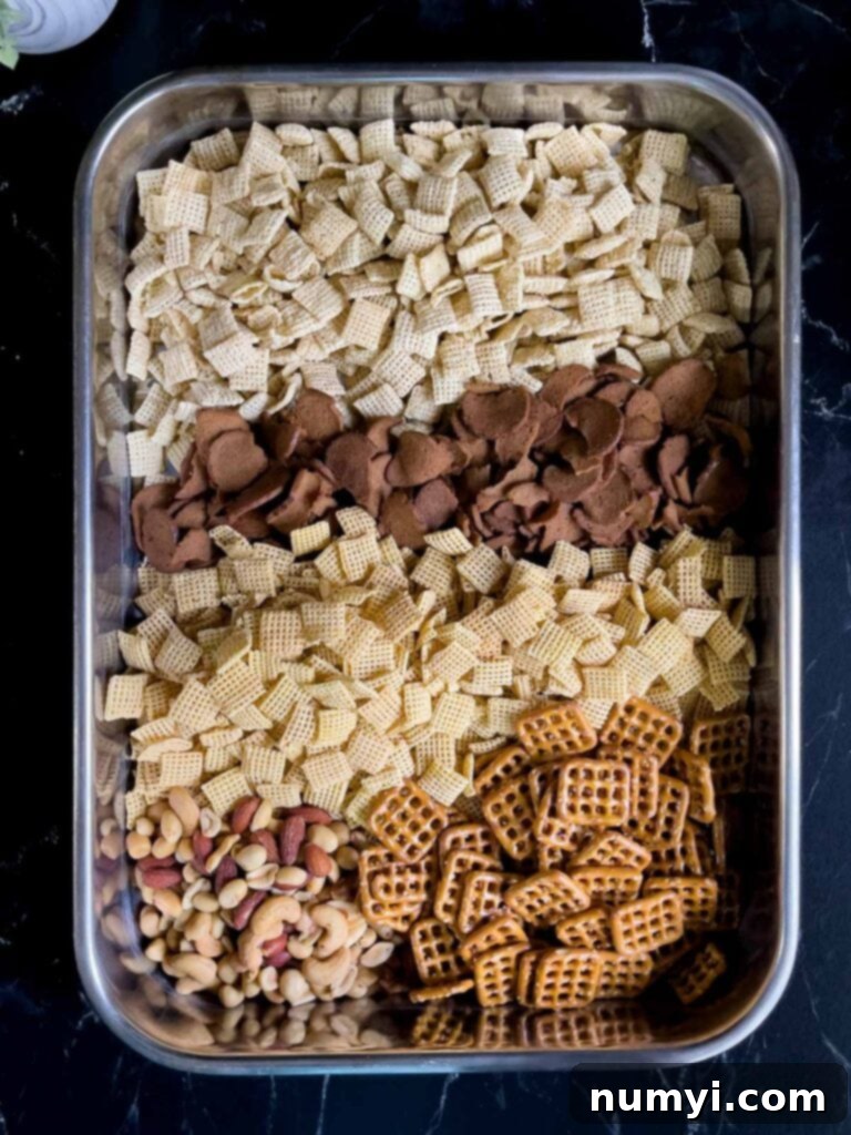 Tangy Dill Chex Crunch 4 Cereal ingredients for Dill Pickle Chex Mix in a large baking pan, ready for seasoning.