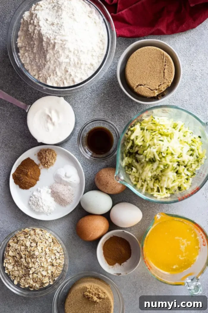 Overhead view of all the key ingredients for zucchini cake laid out in separate bowls, ready for baking.