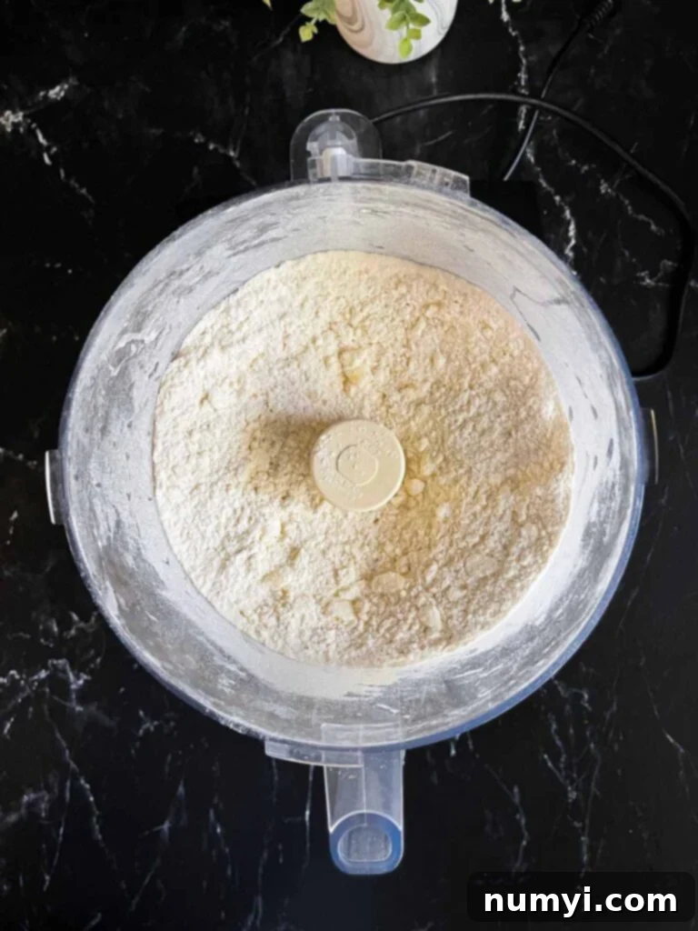 Ingredients for pie crust dough in a food processor, mixed.