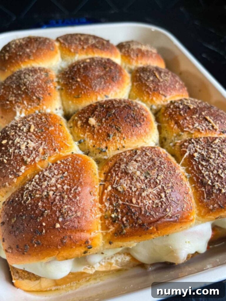 Freshly baked chicken parmesan sliders removed from the oven, cheese perfectly melted.
