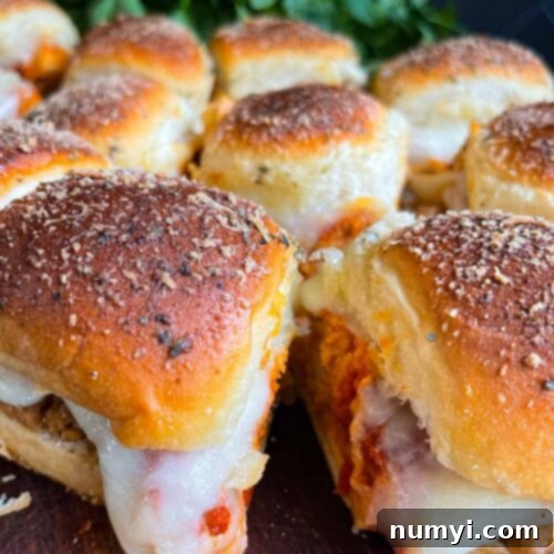 Chicken parmesan sliders on a wooden cutting board.