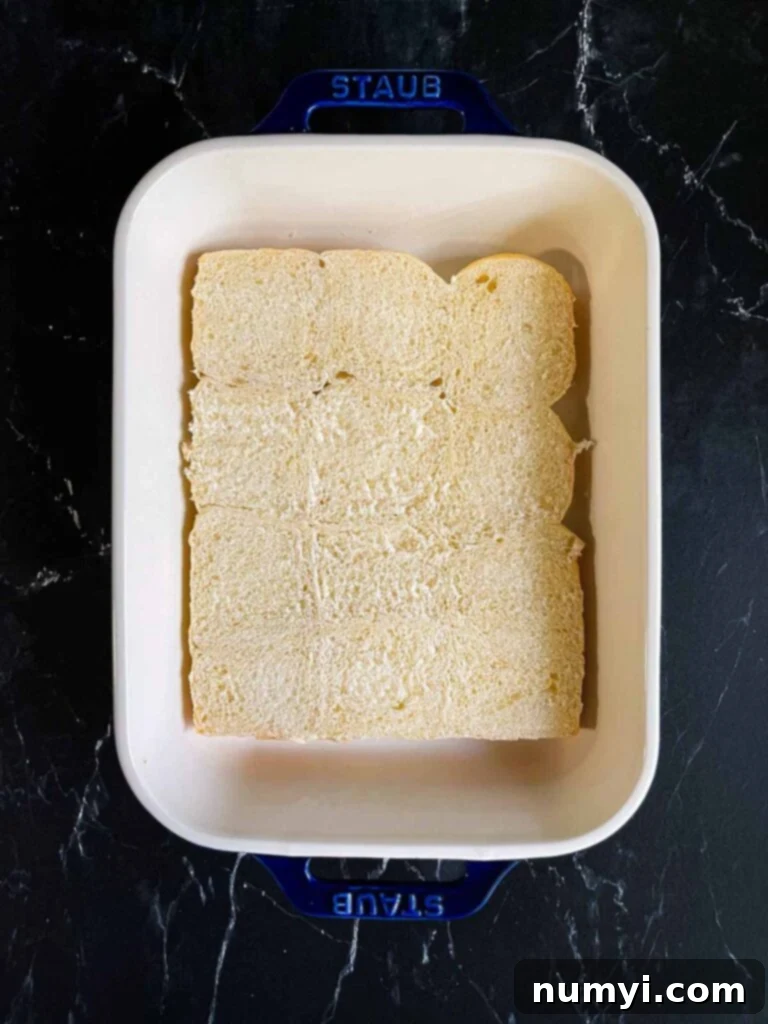 The bottom halves of slider rolls neatly arranged in a 9x13 inch baking dish.