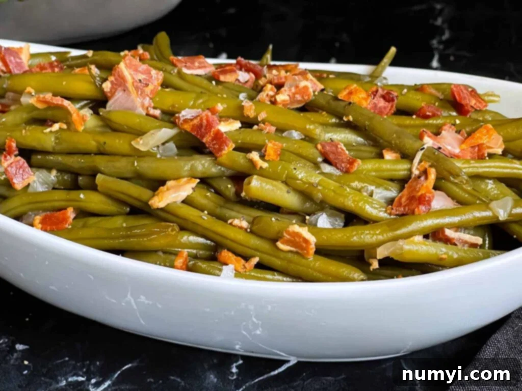 Southern slow cooker green beans in a light bowl on a dark surface.