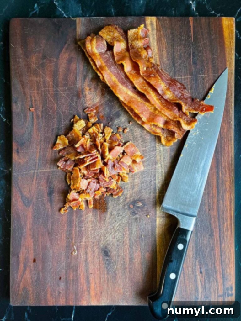Bacon diced on a wooden cutting board.