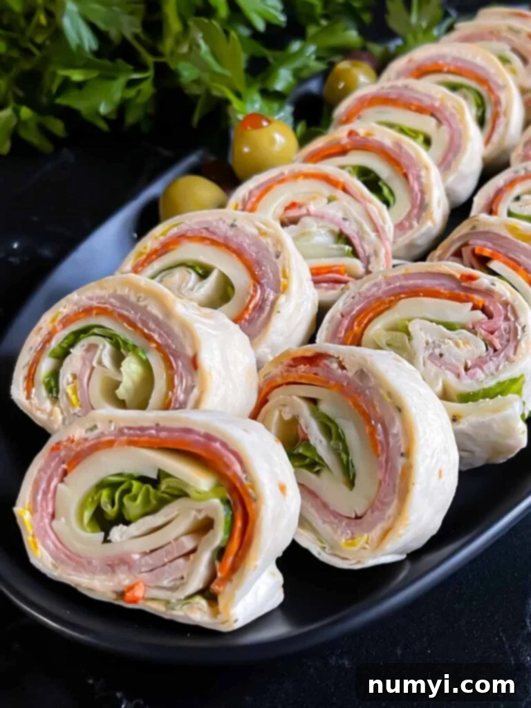 Italian pinwheels on a dark plate on a dark surface, ready to be served as an appetizer.