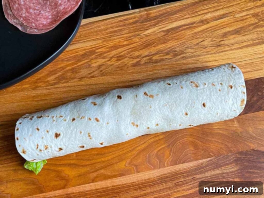 An Italian pinwheel wrap, tightly rolled and ready for chilling, before being sliced.