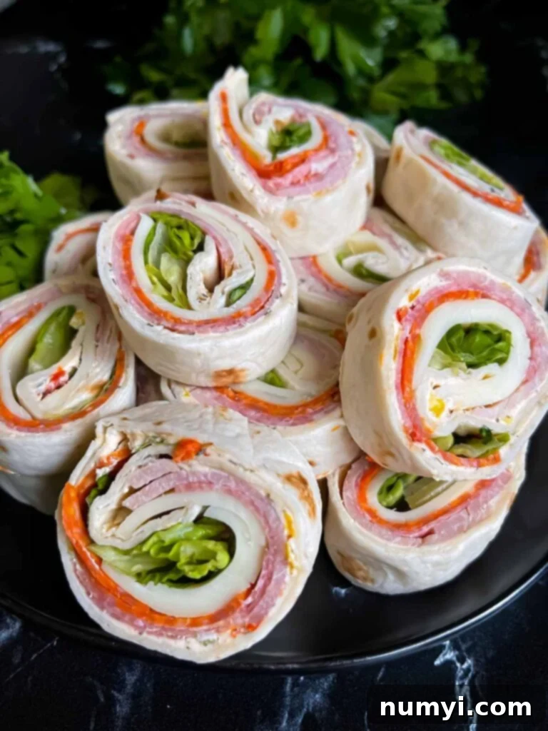 Italian pinwheels artfully arranged on a dark plate on a dark surface, ready for serving.
