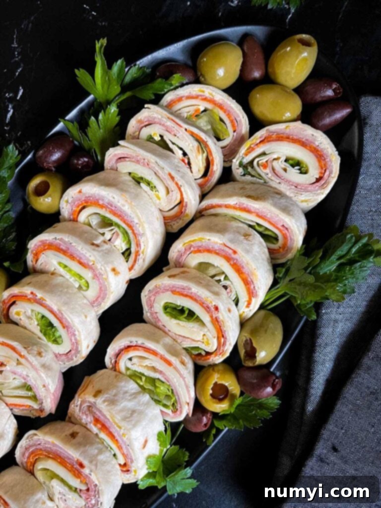 A vibrant display of Italian pinwheels on a dark plate, highlighting their fresh and colorful ingredients.