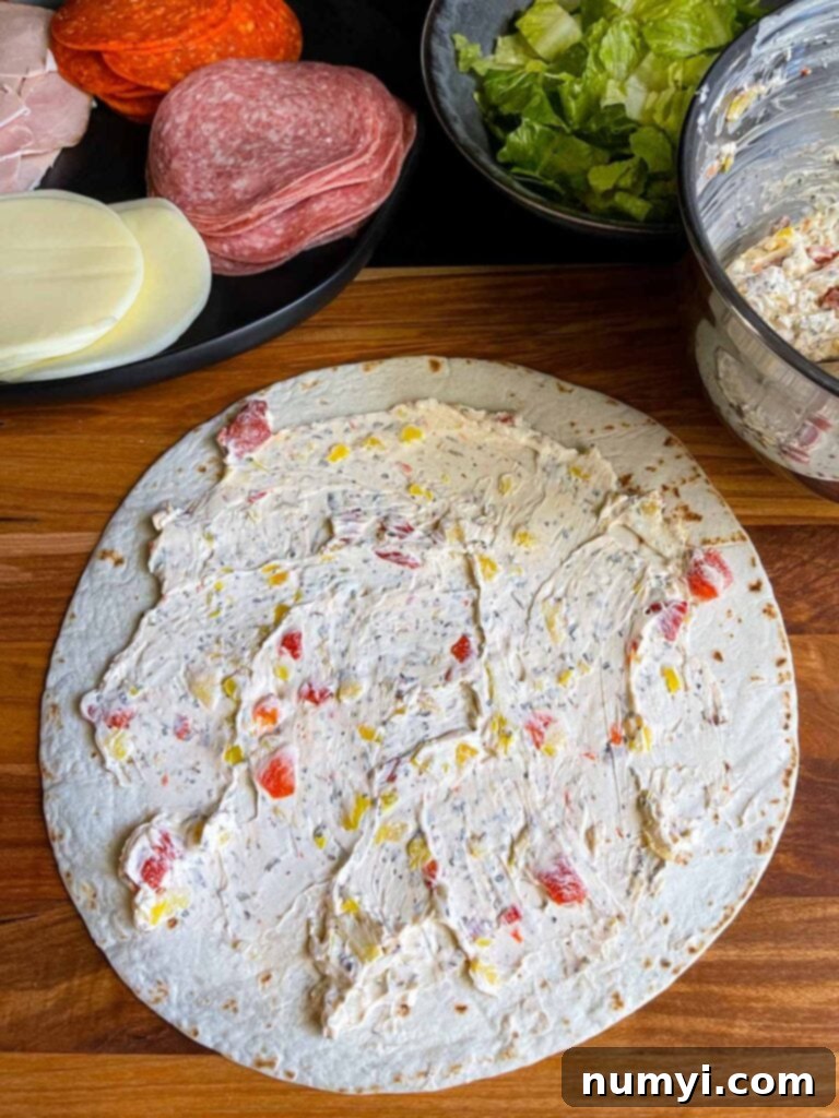 Cream cheese mixture spread evenly across the surface of a large flour tortilla.