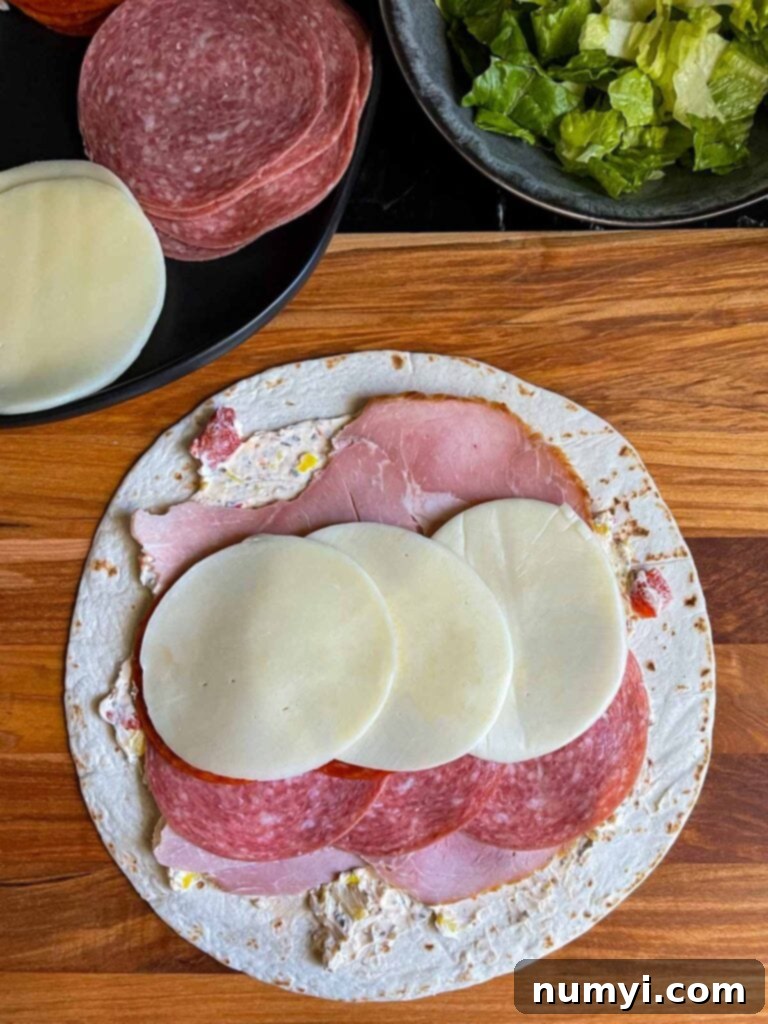 A layer of provolone cheese slices placed over the meats, creating another delicious stratum.