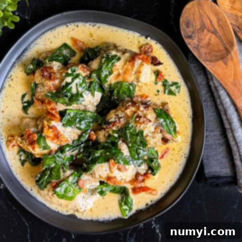 Creamy Slow Cooker Tuscan Chicken 13 Slow Cooker Tuscan Chicken in a dark bowl on a dark surface.
