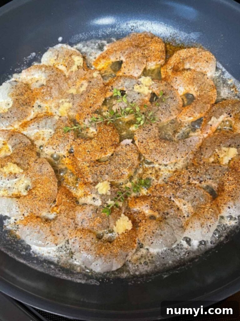 Shrimp cooking in a skillet.
