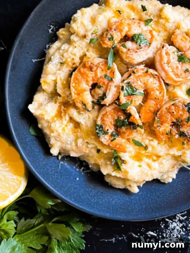 Spicy shrimp on a bed of Cajun polenta in a dark bowl.