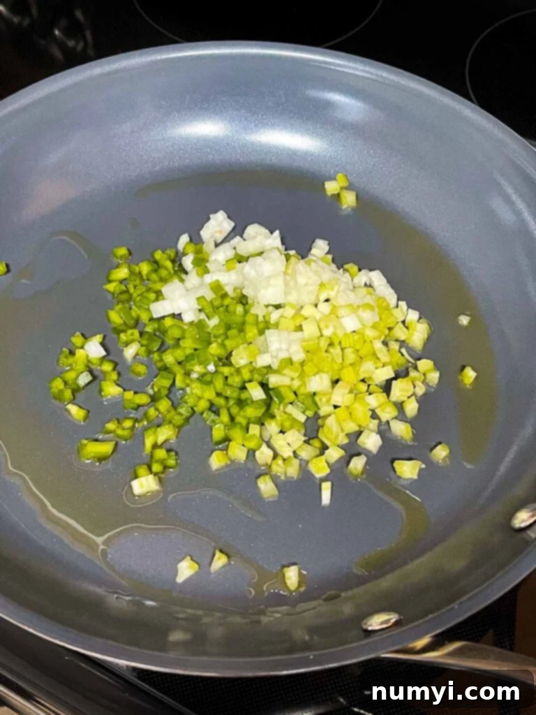 Onions, celery, and green bell pepper with olive oil in a skillet.