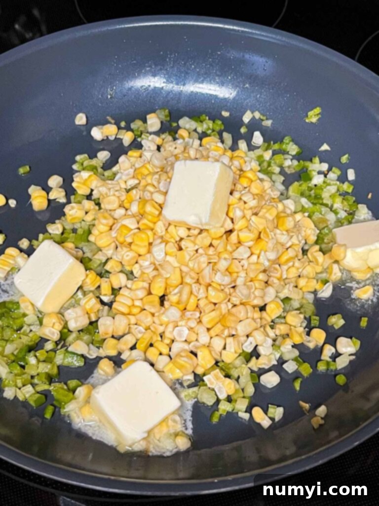 Butter and corn added to a skillet with the holy trinity.
