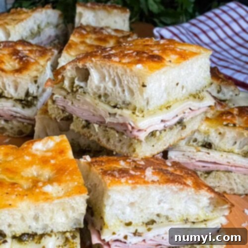 Sliced pesto focaccia sandwiches, on a cutting board, ready to be served.