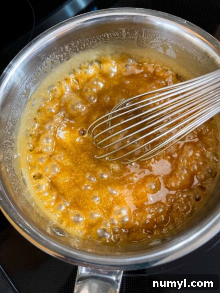 Caramel glaze for apple bundt cake boiling in a medium saucepan.