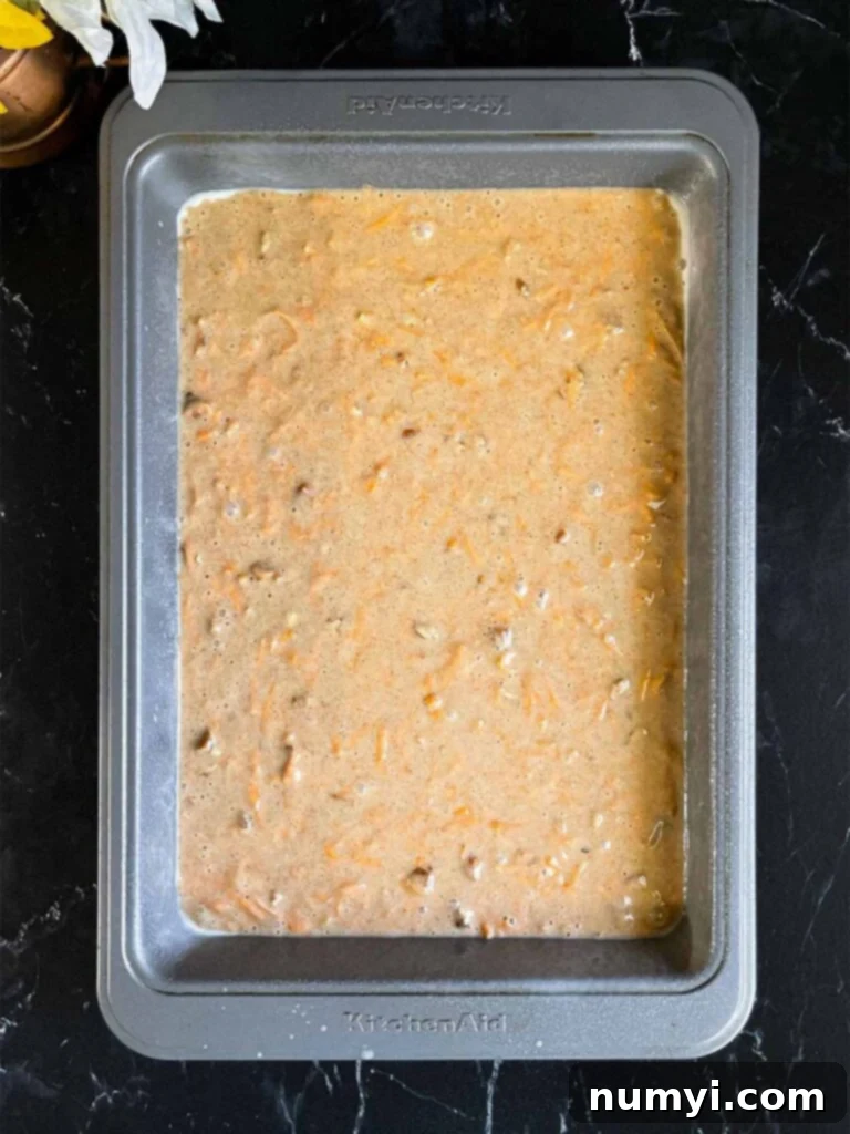 Spiced Sweet Potato Cake 9 Sweet potato cake batter in a 9x13 baking pan on a dark surface.