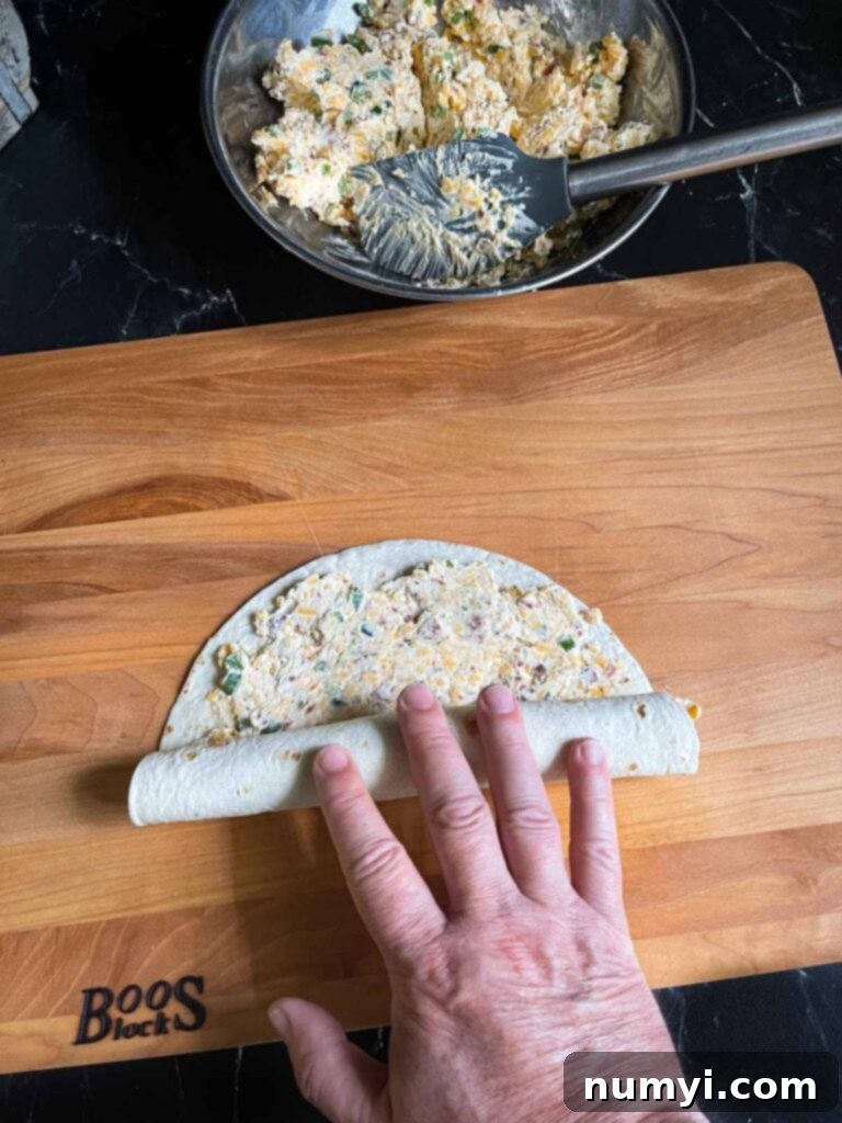 Rolling up a jalapeno popper pinwheel.