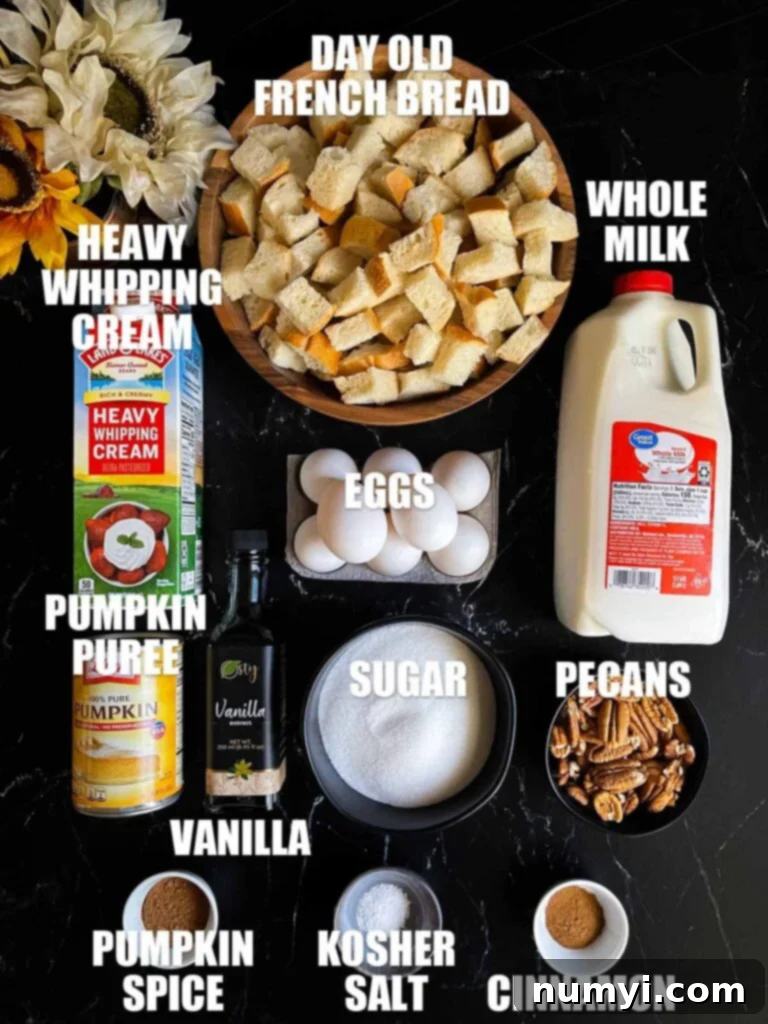 Salted Caramel Swirl Pumpkin Bread Pudding 3 Various key ingredients for pumpkin bread pudding, including bread cubes, eggs, milk, cream, pumpkin puree, and spices, neatly arranged on a rustic dark surface.