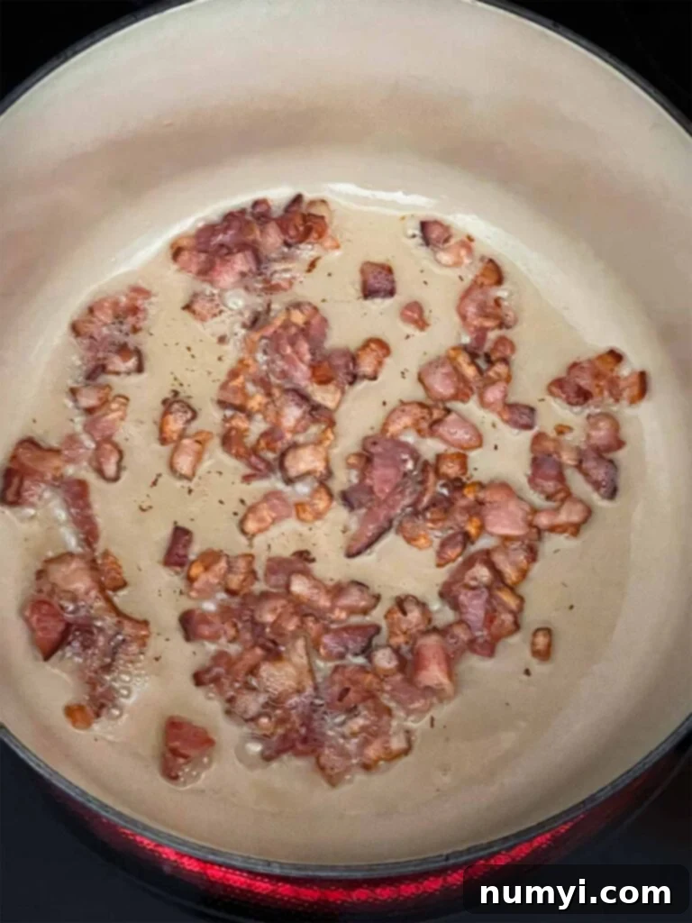 Velvety Potato Corn Chowder with Crispy Bacon 4 Chopped bacon frying in a dutch oven.