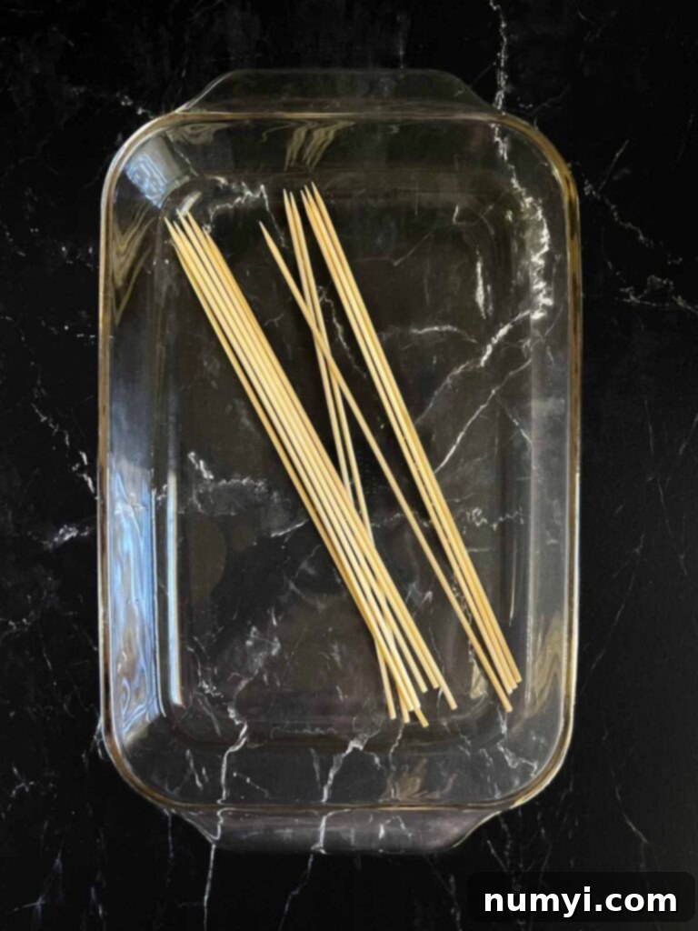 Bamboo skewers soaking in a water bath.