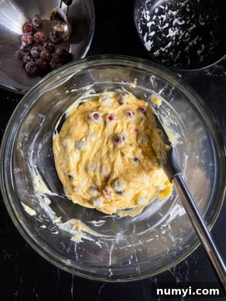 Zesty Cranberry Orange Loaf 9 Ingredients for cranberry orange bread combined in a glass bowl.