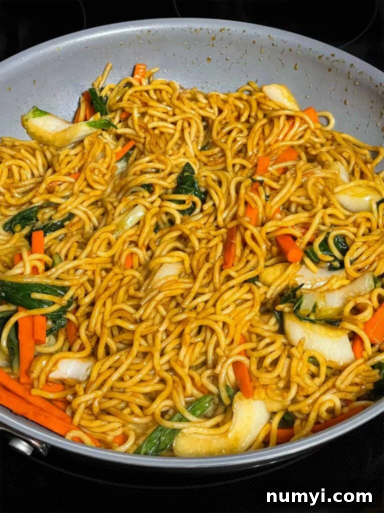 A perfectly stir-fried Vegetable Lo Mein dish, featuring tender noodles and vibrant vegetables coated in a rich, savory sauce, all mingling together in a skillet, ready to be served.