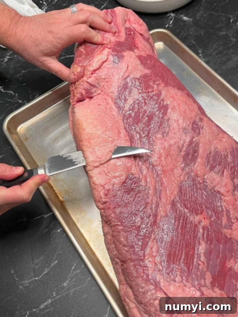 Trimming the deckle out of a brisket.