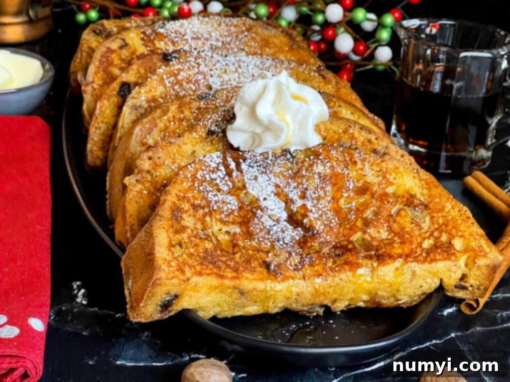 Slices of panettone French toast garnished with powdered sugar, whipped cream, and maple syrup on a dark plate.