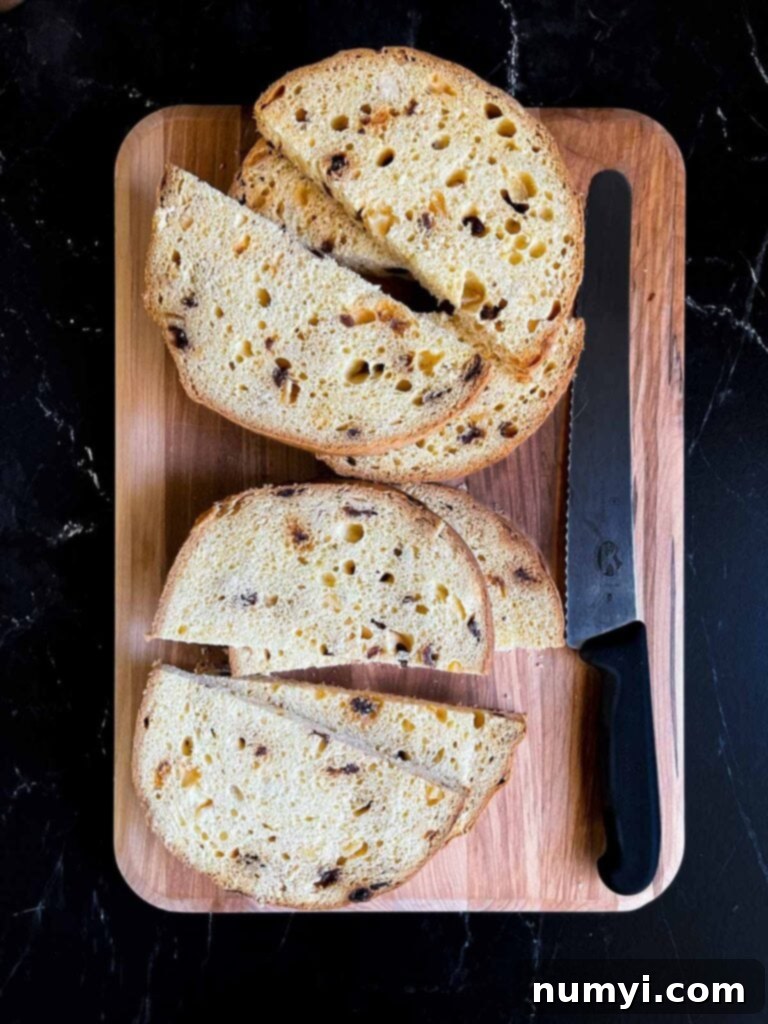 Panettone sliced into half moon slices on a wooden board.