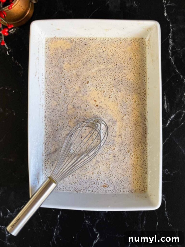 Panettone french toast egg mixture ingredients whisked together in a shallow baking dish.