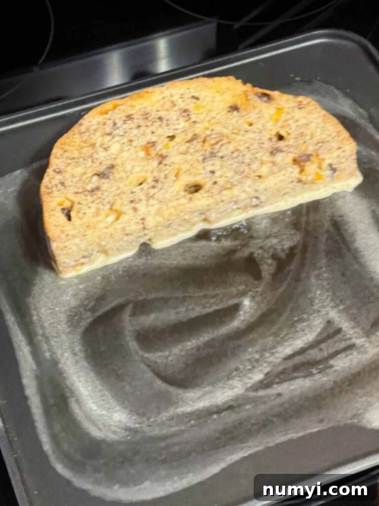Slice of panettone french toast cooking on a buttered griddle.