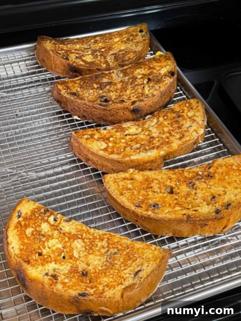 Cooked panettone french toast on a wire rack lined baking sheet.