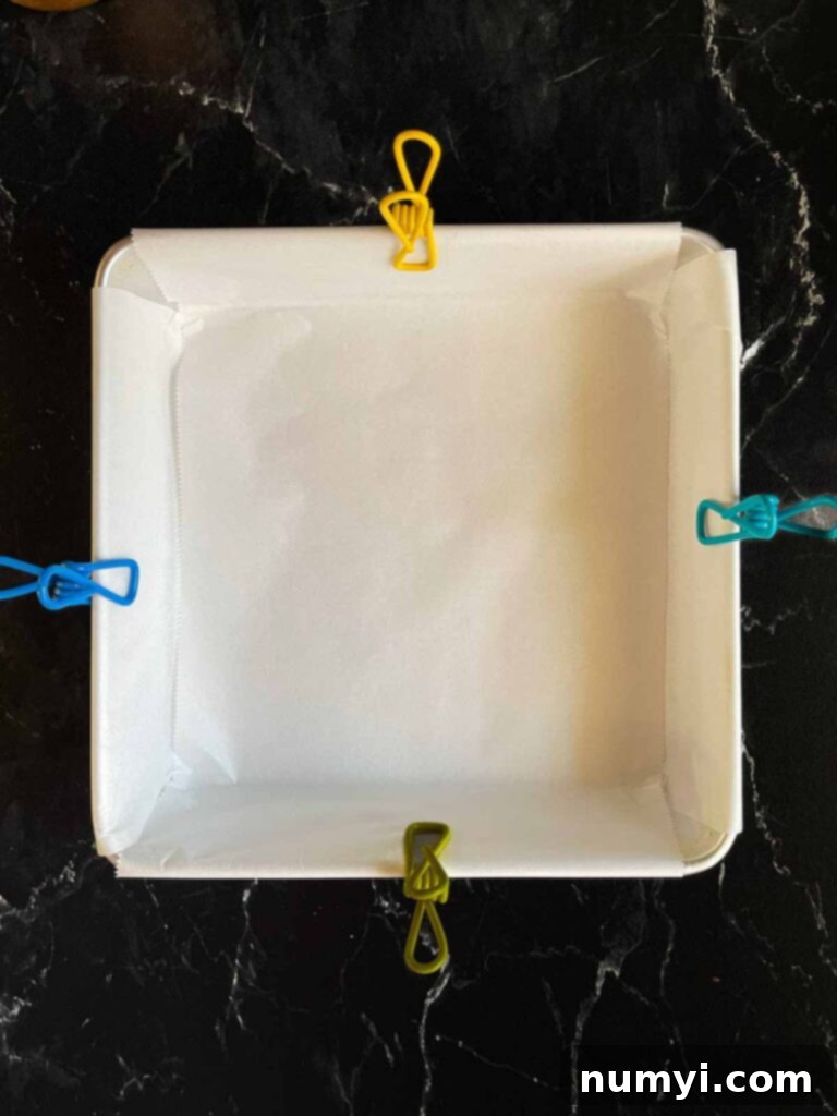 Parchment lined 8x8 baking pan for the eggnog fudge.