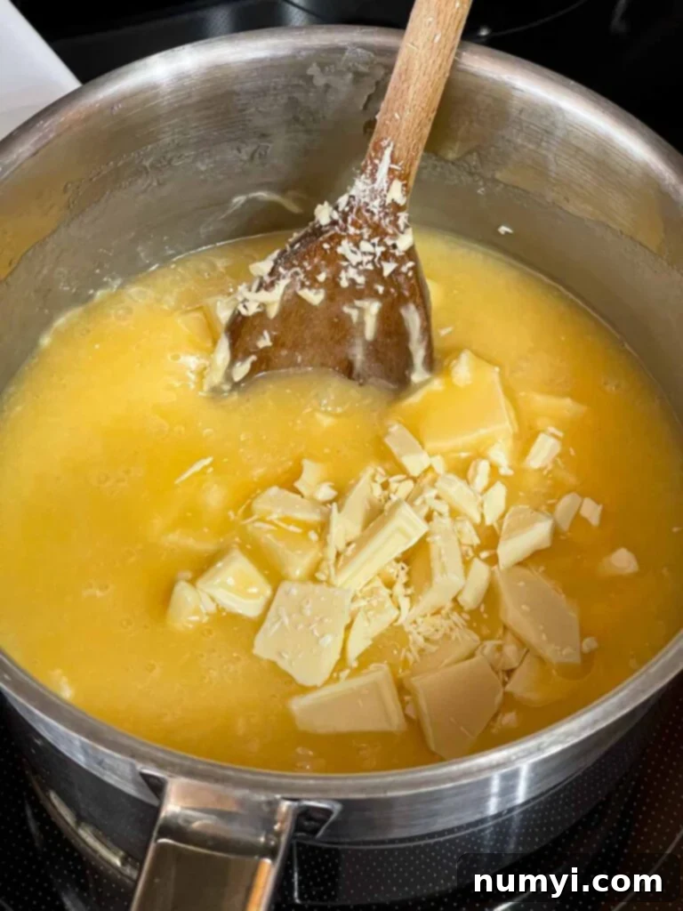 The chopped chocolate added to the boiled eggnog fudge ingredients in a saucepan.