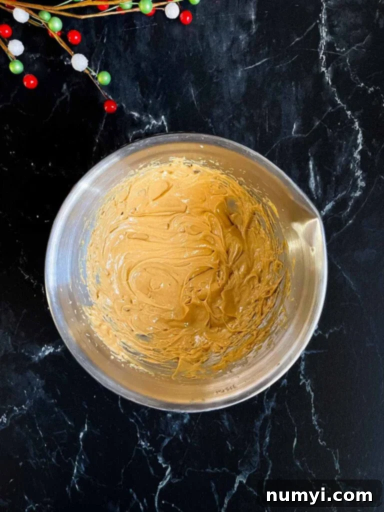 Peanut butter and softened butter mixed together in a metal mixing bowl.