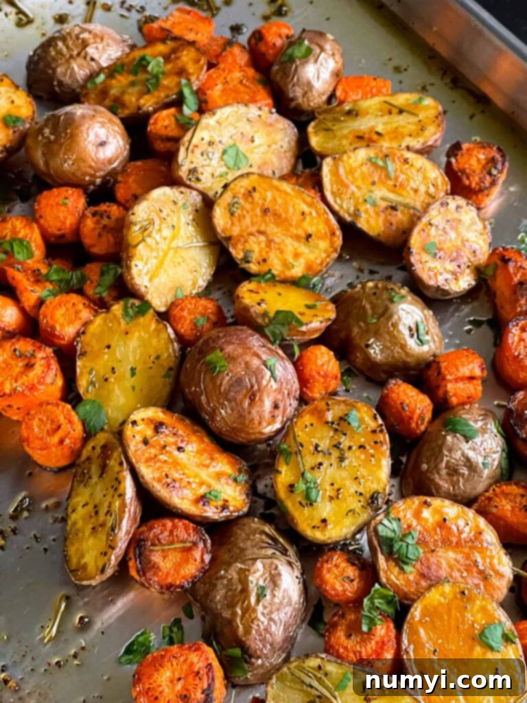 Roasted potatoes and carrots on a baking sheet.