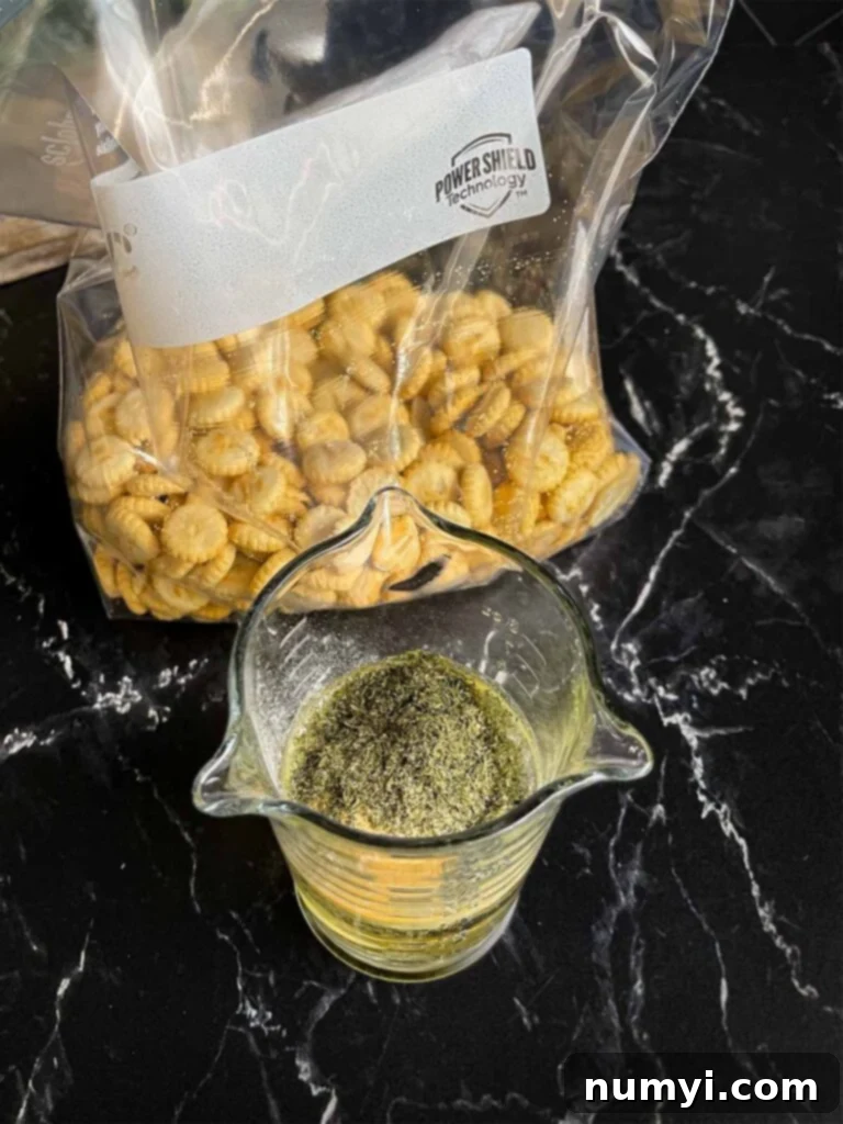 Seasonings for dill oyster crackers being whisked in a glass measuring cup on a dark surface.
