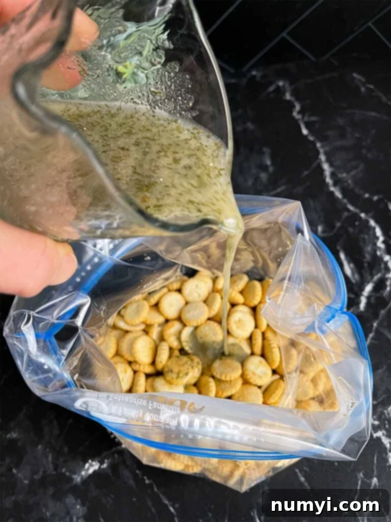 Dill seasoning mixture being poured over the oyster crackers in a resealable plastic bag for even coating.