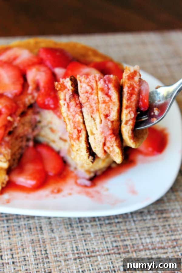 Wholesome Strawberry Pancake Delight 4 a stack of whole wheat strawberry pancakes on a plate with a fork full in the foreground